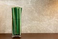 Green sedge leaf in jar on the wood table and marble wall
