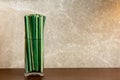 Green sedge leaf in jar on the wood table and marble wall Royalty Free Stock Photo