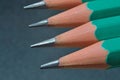 Green sharpened wooden pencils with black lead on a dark textured background. close-up Royalty Free Stock Photo