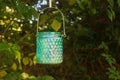 Green shimmering lantern hanging in a garden