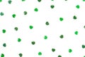 green shimmering shamrock confetti sparse on white background