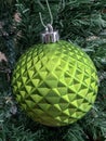 Green Shiny Round Christmas Ornament Hanging on a Tree