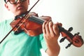 Green shirt boy playing violin in house room. Royalty Free Stock Photo