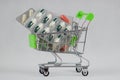 Green shopping cart with medicaments on an isolated white background. Royalty Free Stock Photo