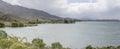 Green shore under barren slopes at Benmore lake, New Zealand Royalty Free Stock Photo