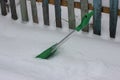 Green shovel for snow removal in the yard of a private house. clean the path at the entrance to the gate in snowy winter