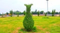 Green shrubs manicured and shaped to look like animal and pot.plants sculptured.Wonderful Spring flowers