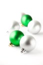 Green and silver Christmas baubles on white