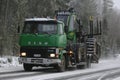 Green SISU Truck Hauls John Deere Forwarder in Winter