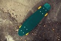 Green skateboard on the background of textured asphalt