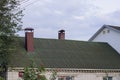 Green slate roof of a private brick house with brown metal chimneys Royalty Free Stock Photo