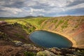 Green slopes on the edge of the crater lake of the Kerid crater in Iceland.