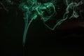 Green smoke trails swirling on the black background Royalty Free Stock Photo