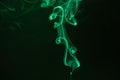 Green smoke trails swirling on the black background Royalty Free Stock Photo