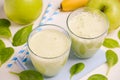 Green smoothie with apple, banana and spinach on a white background.