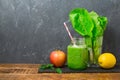 Green smoothie with apple, lettuce and lemon over dark background. Detox, dieting, vegetarian, fitness or healthy eating Royalty Free Stock Photo