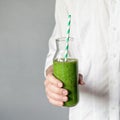 Green smoothie bottle in hands Royalty Free Stock Photo