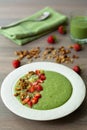 Green smoothie bowl with banana, strawberry, spinach, kale, kiwi, coconut milk garnished with homemade granola and fruits Royalty Free Stock Photo