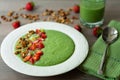 Green smoothie bowl with banana, strawberry, spinach, kale, kiwi, coconut milk garnished with homemade granola and fruits Royalty Free Stock Photo