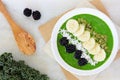 Green smoothie bowl overhead scene on white marble Royalty Free Stock Photo