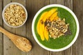 Green smoothie bowl overhead view on wood with spoon Royalty Free Stock Photo