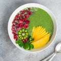 green smoothie bowl with spinach, mango, kiwi and raspberry. Healthy vegan raw food Royalty Free Stock Photo