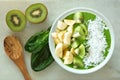 Green smoothie bowl with spoon on white marble Royalty Free Stock Photo