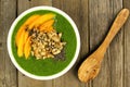 Green smoothie bowl on wood background with spoon Royalty Free Stock Photo