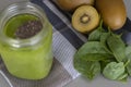 Green smoothie with chia in mason jar on gray background with kiwis and spinach.Healthy diet concept with spinach, pineapple, kiwi Royalty Free Stock Photo