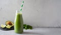 Green smoothie in glass bottle with paper straw. Delicious avocado beverage