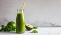 Green smoothie in glass bottle with paper straw. Delicious avocado beverage