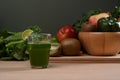 Green smoothie in glass and fresh green vegetables on wooden table. Healthy food. Royalty Free Stock Photo