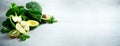 Green smoothie in glass jar with fresh organic green vegetables and fruits on grey background. Spring diet, healthy raw