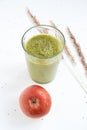 Green smoothie in a glass, spike, red apple. Royalty Free Stock Photo