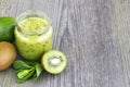 Green smoothie with kiwi fruit, cucumber, mint and parsley on old grey wooden desk