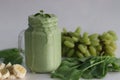 Green smoothie made of frozen green grapes, fresh baby spinach, bananas and almond milk. Served in mason jar Royalty Free Stock Photo