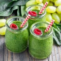 Green smoothie with spinach, grape and banana, garnished with raspberries, square Royalty Free Stock Photo