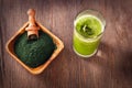 Green smoothie with spirulina on wood background