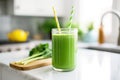 green smoothie with a stripey straw on a kitchen countertop