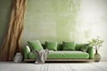 Green sofa against grunge distressed painted stucco wall and wooden decorative tree trunk. Minimalist home interior design of