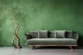 Green sofa against grunge distressed painted stucco wall and wooden decorative tree trunk. Minimalist home interior design