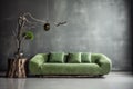 Green sofa against grunge distressed painted stucco wall and wooden decorative tree trunk. Minimalist home interior design