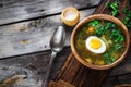 Green soup with sorrel in wooden bowl.