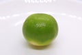 one green sour lime on a plate