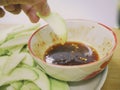 Green sour mango raw mango with sweet fish sauce on a wooden table. Hand is picking raw mango Royalty Free Stock Photo