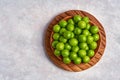 Green sour plum in wooden bowl . Top view with copy space Royalty Free Stock Photo