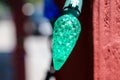 Green sparkly single Christmas light illuminated with a blurry background