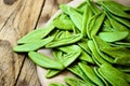 Green spinach italian pasta in the shape of olive leaves, scattered on wooden plate, mediterranean cuisine Royalty Free Stock Photo