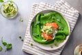 Green spinach pancakes crepes, blini with salmon, mashed avocado, peas, arugula.