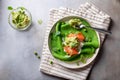 Green spinach pancakes crepes, blini served with salmon, mashed avocado, peas, arugula.